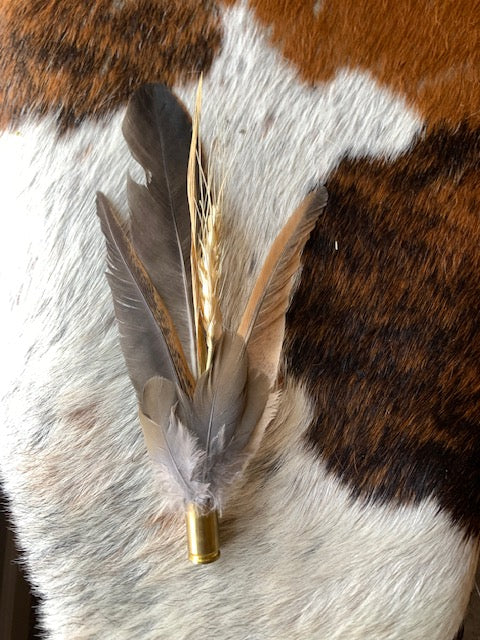 Feather/wheat cluster with empty bullet casing